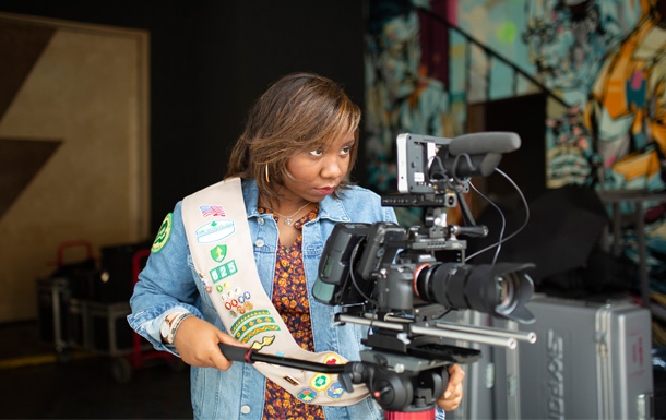 an older girl scout operating a video camera