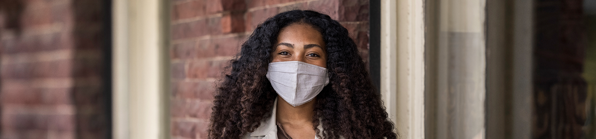  girl in face mask looking at camera with smiling eyes 