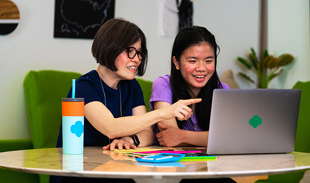 mom and daughter sitting side by side at computer