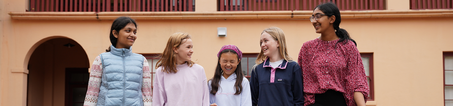  group of girl scouts walking outside smiling at camera 