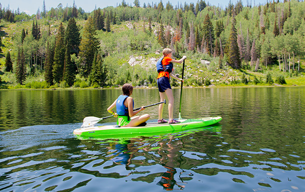 two girls paddle boarding on a lake