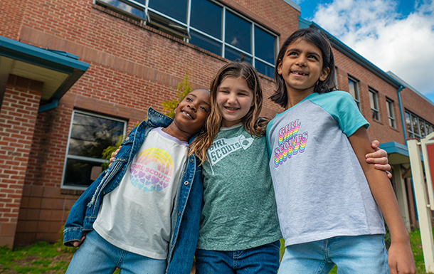 Two girls with their arms around each other's shoulders