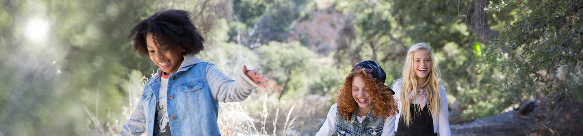  three girl scouts walking on a trail 